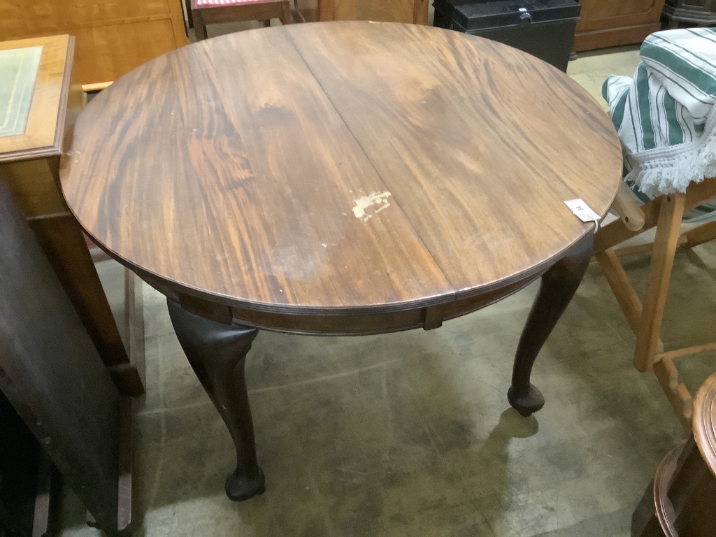 A 1920's circular mahogany extending dining table with three leaves and handle, length approx. 230cm